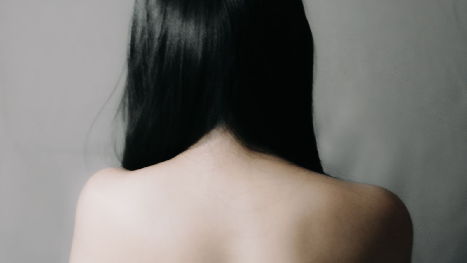 A shoulder and back in soft, warm light, seen in shallow focus