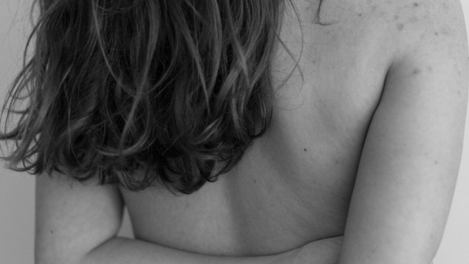 A bare shoulder and back in soft, high-key light