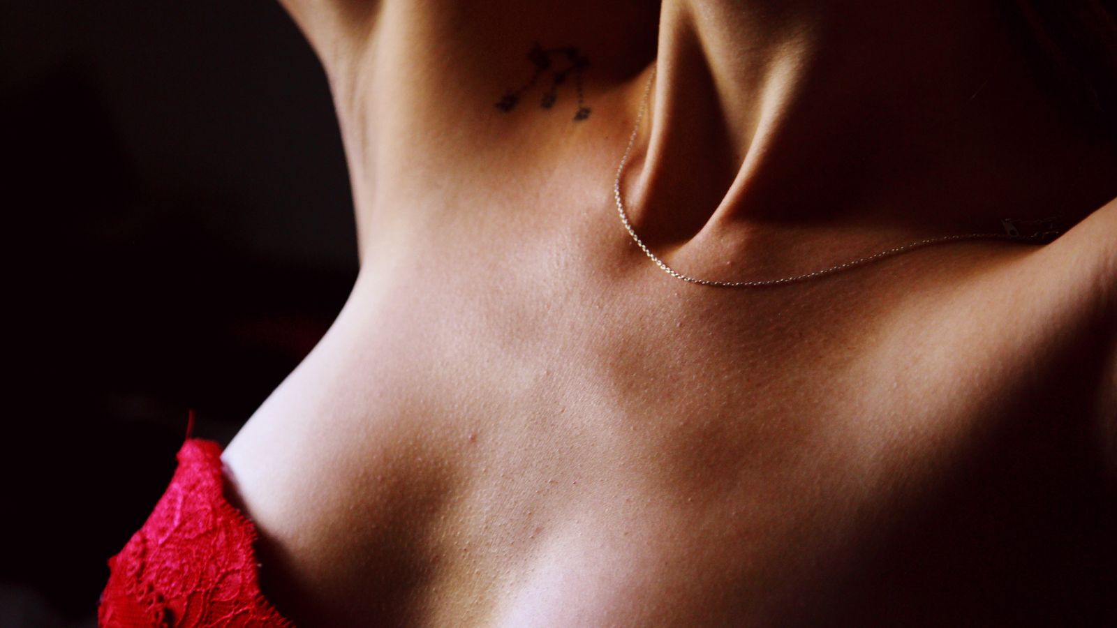 A bare shoulder and collarbone in warm low light, a study in form and shadow.