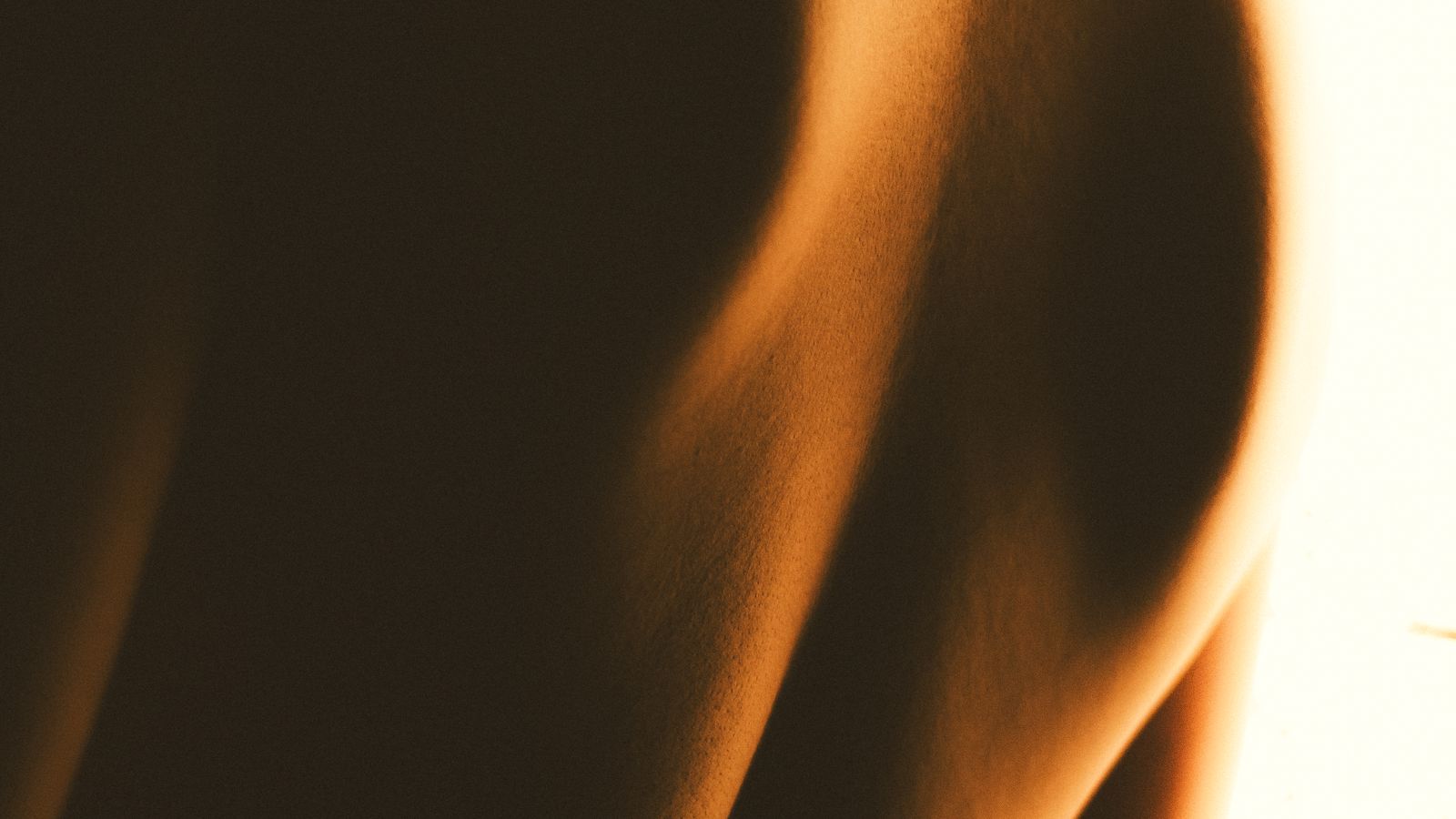 The warm curve of a body in soft, low light.