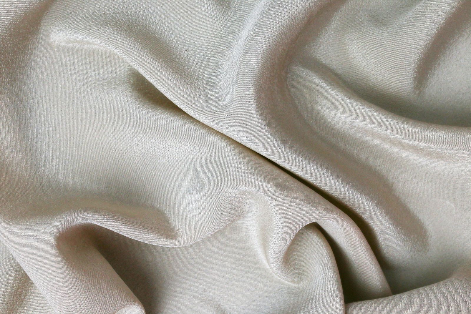 Folds of pale cream silk catching light in soft ripples